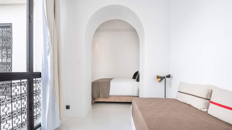 Bedroom 2: the queen bed in its arched alcove and, in front, a single bed along the wall.